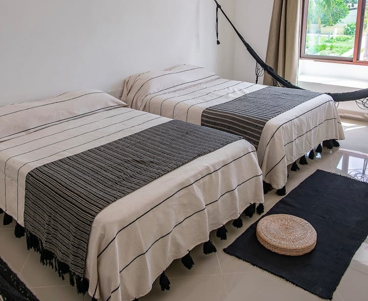 Slaapkamer twee tweepersoonsbedden en twee hangmatten 