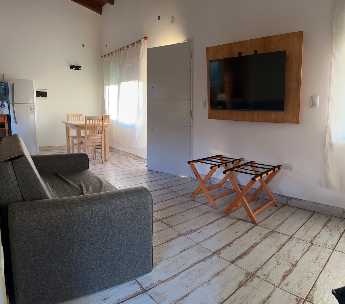 Pequeño espacio de living, que separa sector cocina de sector dormitorio.  Smart TV y sillón cama de 1,10 m de ancho