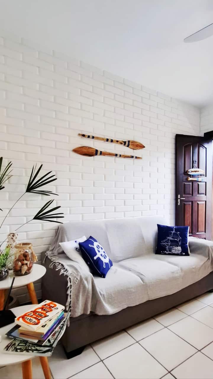 Divano a  posti, tavolino ad angolo con decorazioni regionali, libri, connessione Internet e un vaso di rafia!