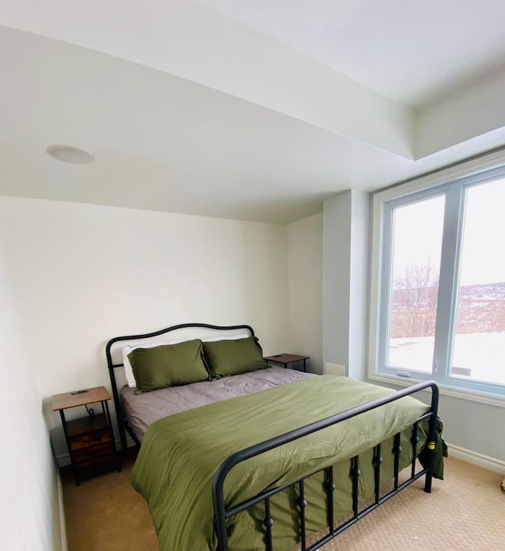 חדר שינה מואר עם מיטת קווין סייז