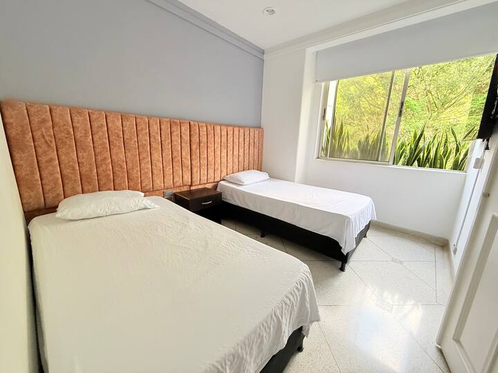 חדר נעים, עם אור טבעי, טלוויזיה ומקום לבגדים.