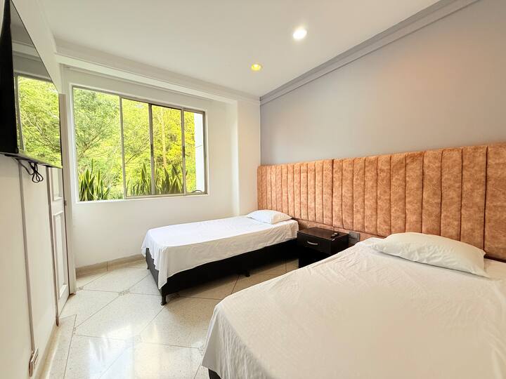 חדר עם תאורה טובה, טלוויזיה, ארון לאחסון בגדים ותאורה טובה.