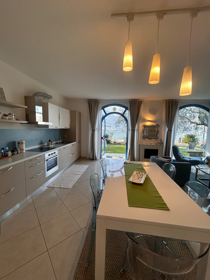 Cuisine équipée avec table à manger et vue sur le jardin et le lac