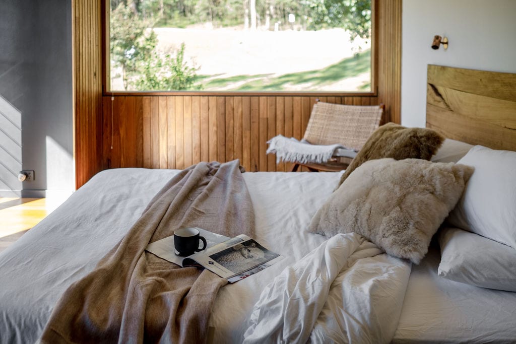 Master bedroom with large windows over pond and paddocks