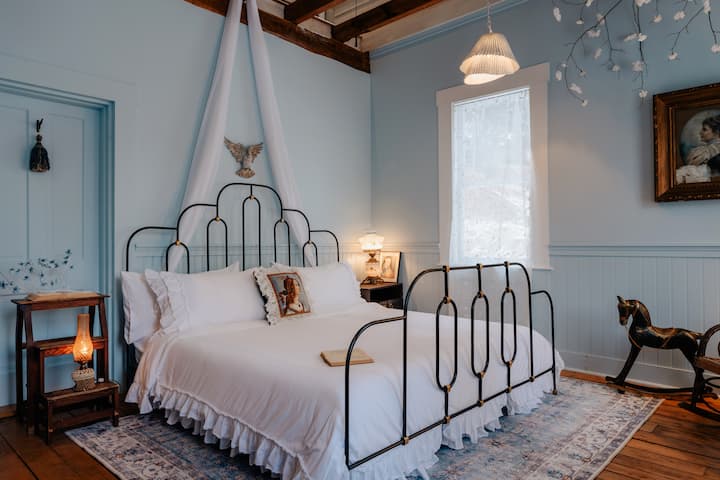 Drift off to dreamland in the enchanting Blue Room, where calming vibes, a cozy king bed, and decorative treasures from the past meet.