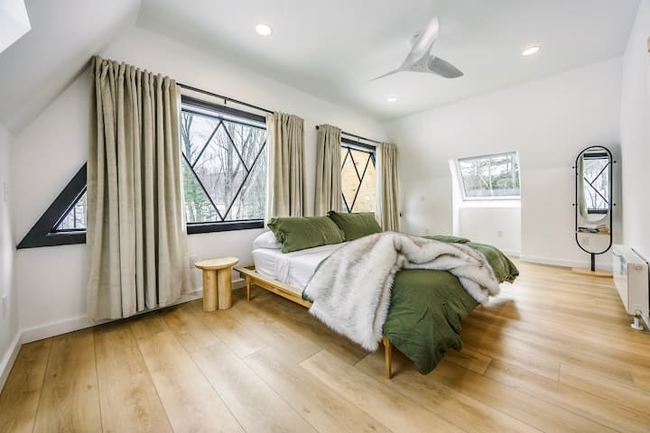 Comfortable king sized bed, with USB A/USB C charging ports located on each side of the bed and blackout curtains. Located on 2nd floor.