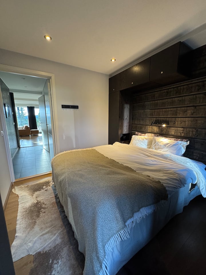 Generous bedroom with double bed, made with down duvet and down pillows. Guests can take advantage of the built-in storage in the form of a wardrobe, hook strips and a spacious bed drawer under the bed.