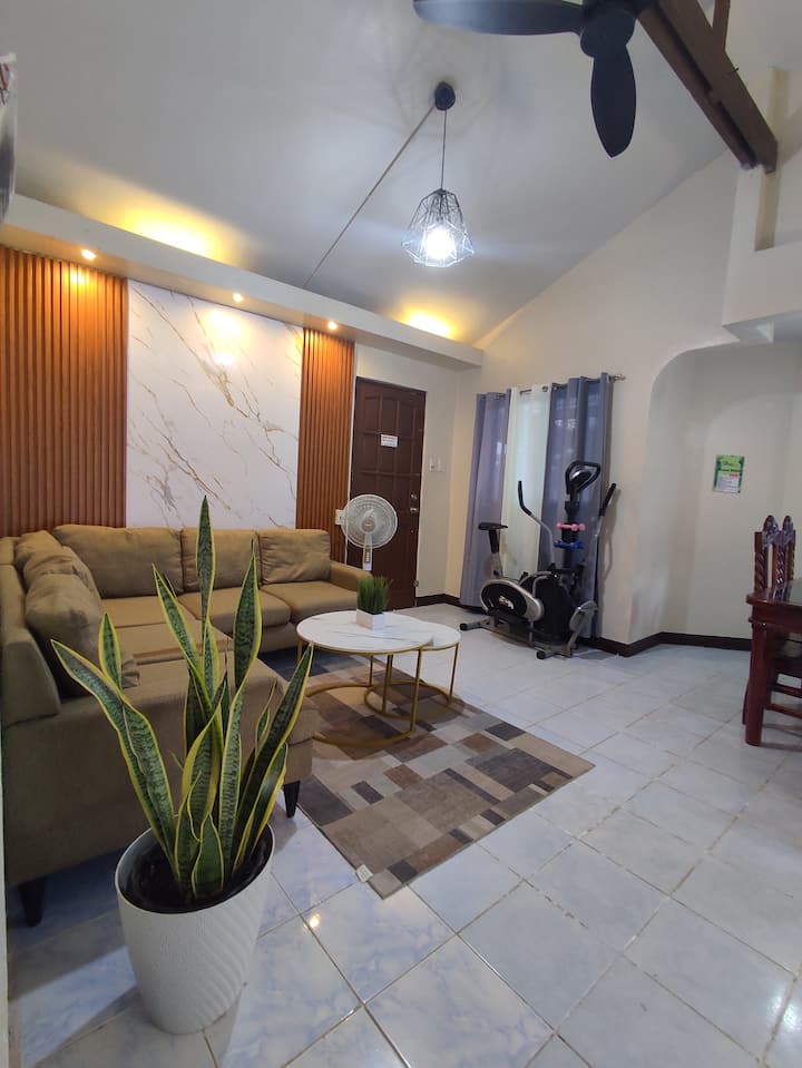 סלון נעים ומרווח עם מאוורר תקרה ומאוורר עומד.