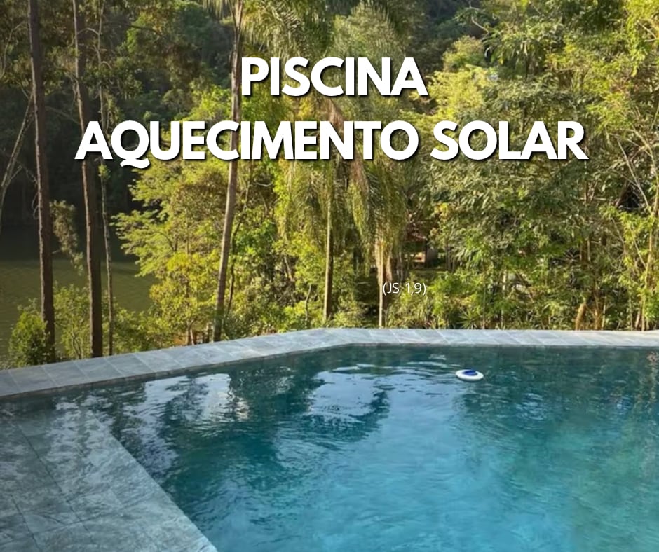 A solar-heated swimming pool is set against a backdrop of lush greenery and a calm body of water. The pool's clear blue surface reflects sunlight, creating a tranquil environment for relaxation and enjoyment. Surrounding trees add to the serene atmosphere.