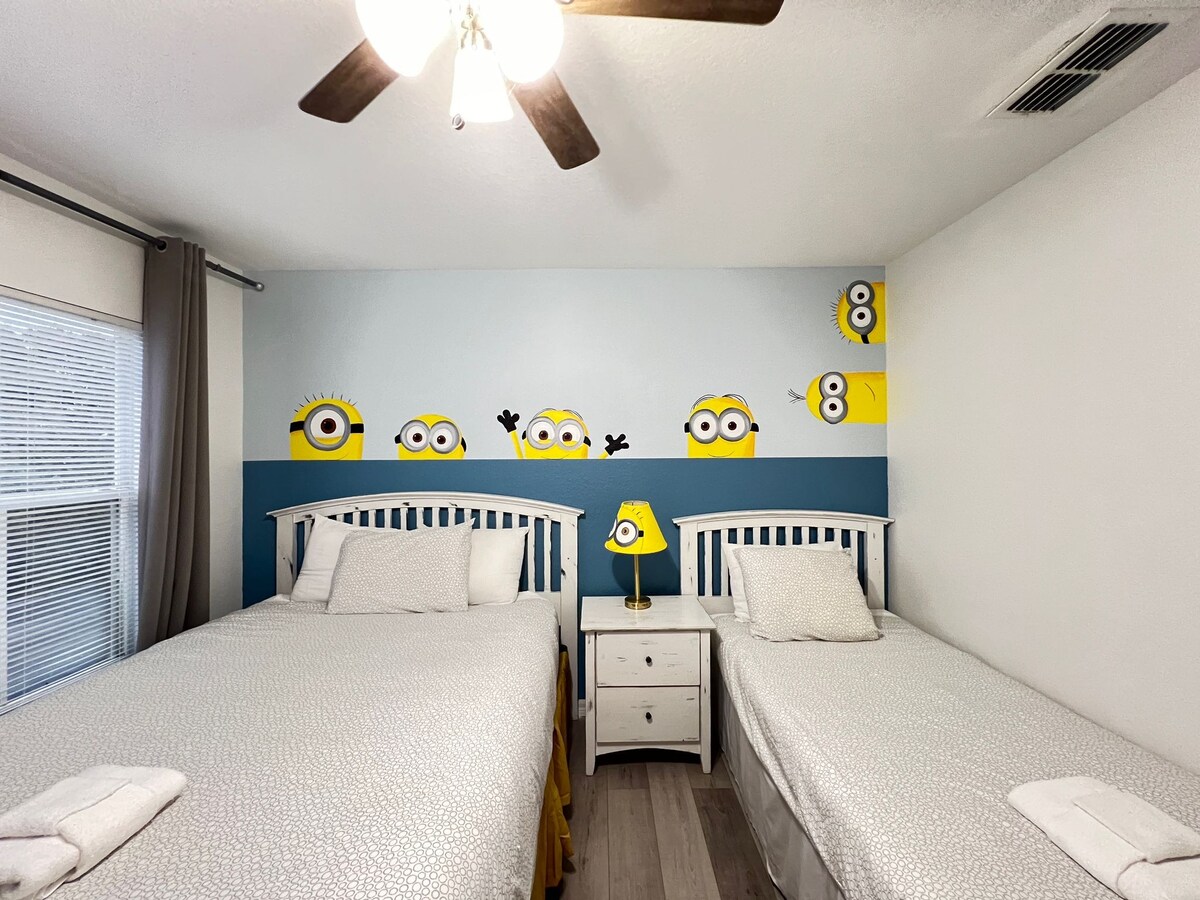 من المؤكد أن غرفة النوم هذه تحت عنوان مينيون ستسعد الصغار والكبار على حد سواء. مع نظام ألوان مرحة وشارات جدارية رائعة، فهي المكان المثالي للاسترخاء بعد يوم من الاستكشاف.