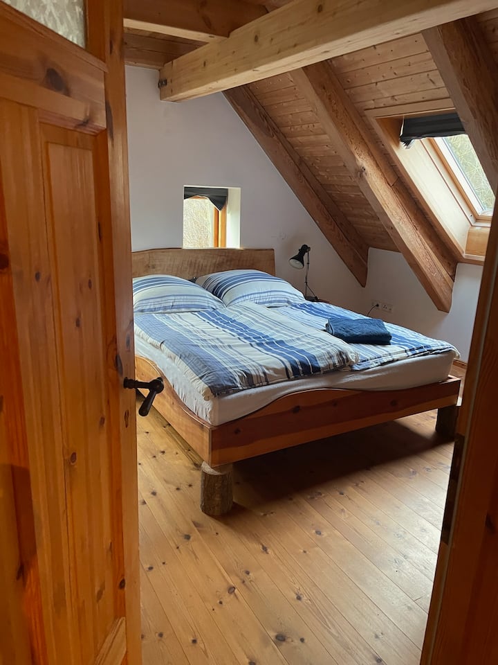 S otvorenog hodnika možete otići  u spavaću sobu 1 s bračnim krevetom (160x200). Večernje sunce obasjava zapadne prozore, a pogled na dvorište s krovnog prozora. Ormar i komoda nude dovoljno prostora za odlaganje.