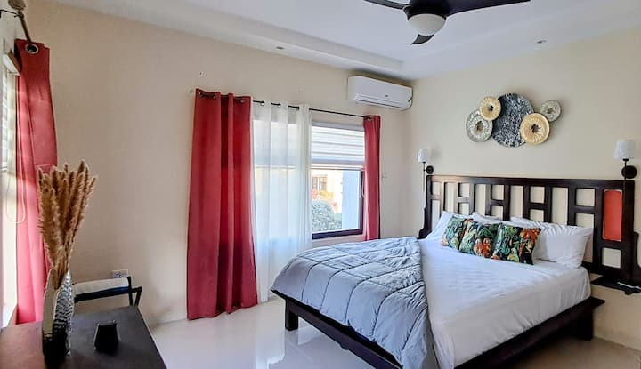 Oddýchnite si v našej pokojnej spálni s pohodlnou posteľnou bielizňou, teplými tropickými farbami a relaxačnou atmosférou. Je to dokonalé útočisko po dni objavovania, ktoré ponúka pokojný únik v pohodlí.