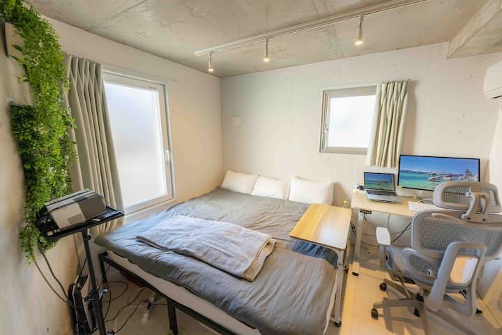 Брачниот кревет (два единечни кревета споени во еден), сонцето и освежителното вештачко зеленило покрај прозорецот создаваат мирна средина каде што можете да работите.Во собата нема лаптоп.