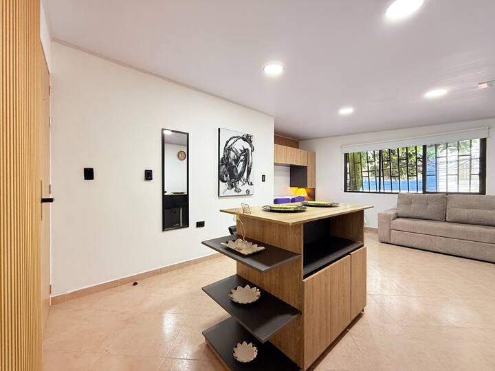 Udoban prostor s modernim dizajnom i svijetlom atmosferom, s udobnom sofom i prozorima koji nude pogled na prirodu.