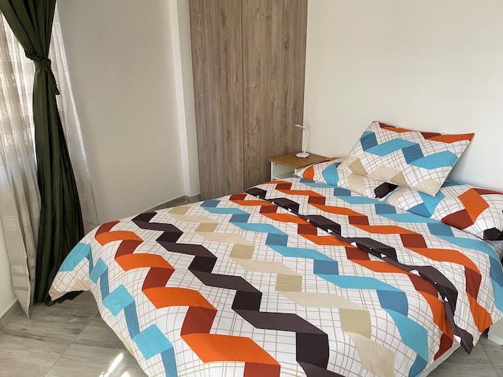 Værelse med en 140x190 cm dobbeltseng, sengeborde med 3-niveauers LED-lamper, blødt sengetøj og et tæppe for en god hvile. Skab med skuffer og bøjler. Hyggeligt rum, ideelt til afslapning og god søvn.