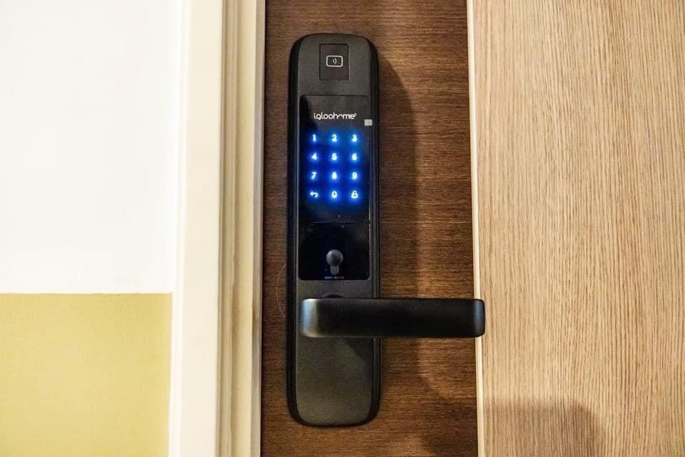 A modern electronic door lock is displayed on a wooden door. The keypad features illuminated numbers against a dark panel, allowing for secure access. A sleek handle is positioned below, providing a minimalistic design that emphasizes convenience and security.