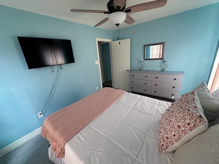 这是主卧室，还包括一个独立的电视。 房源内还有一个梳妆台，可用于存放衣物或个人物品。