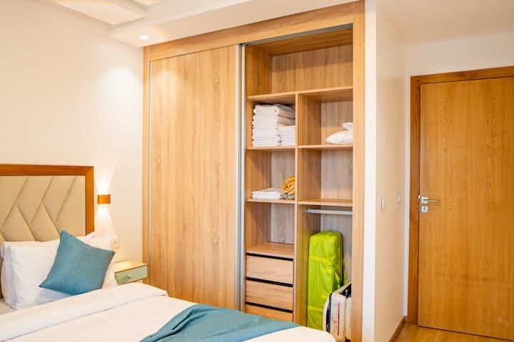 ตู้เสื้อผ้าในห้องนอนแรกพร้อมเตียงเด็ก เรามีผ้าเช็ดตัวและผ้าปูที่นอนเสริมให้ 