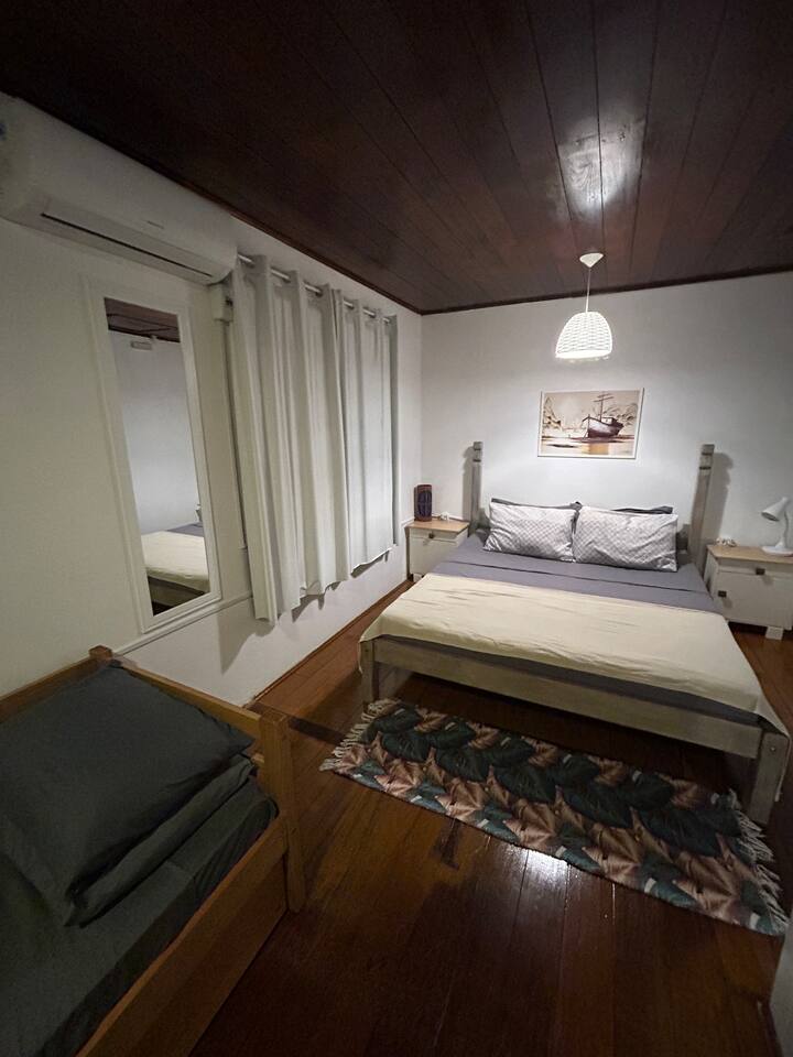 غرفة كبيرة ومريحة بسرير بحجم كوين ومرآة كاملة الطول وإضاءة ناعمة وبيئة مُعدة لليالي مريحة.