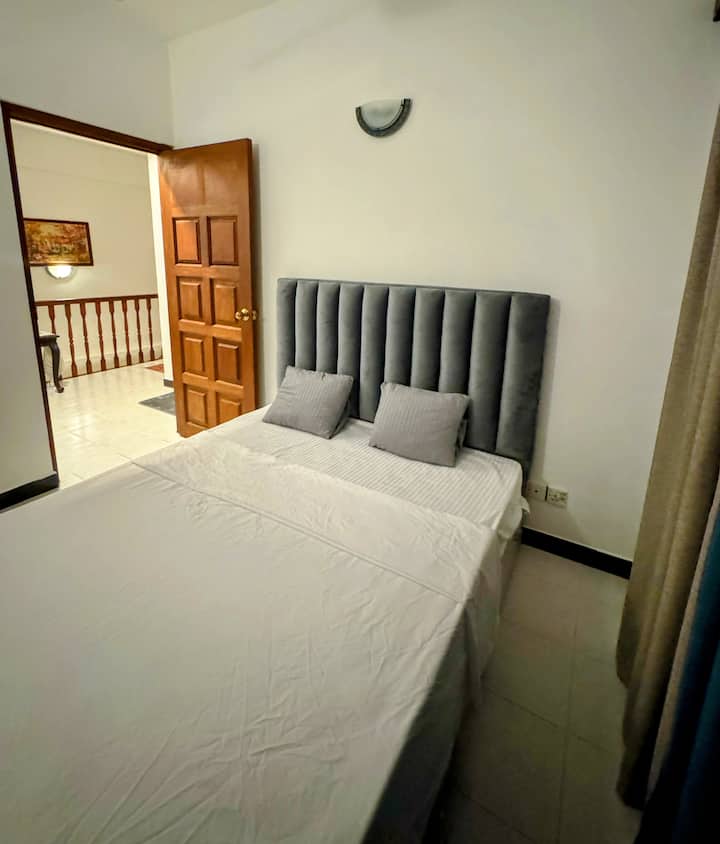 Oddýchnite si v tejto útulnej spálni s plyšovým zamatovým čelom, mäkkou posteľnou bielizňou a pokojnou atmosférou. Užite si ľahký prístup k štýlovému zariadeniu s klasickými drevenými prvkami. Tento priestor je ideálny na pokojný pobyt a spája pohodlie a šarm v príjemnom prostredí.