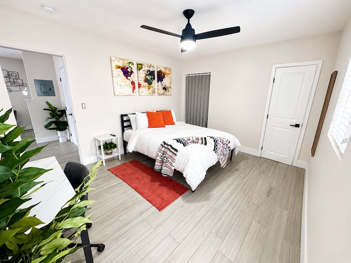 Recámara moderna y luminosa con cama queen, espacio de trabajo y ventilador de techo