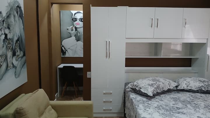 Espaçodo room with janelão  front 

Nová klimatizácia s digitálnym ovládaním

Výkonný stropný ventilátor

domáca kancelária integrovaná do miestnosti / stola a stoličky

 Persiana, ktorá zabraňuje jasnosti 

Ortopedické lôžko

 TV de 50 

Jednolôžková pohovka