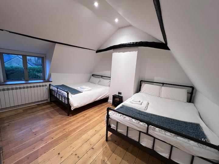 El dormitorio 2 cuenta con dos camas de tamaño completo, impresionantes vigas de madera, pisos de madera, medio baño y los sonidos relajantes del río y los búhos por la noche. Su encanto rústico y su ambiente acogedor lo convierten en un refugio tranquilo en el corazón de Nunney.