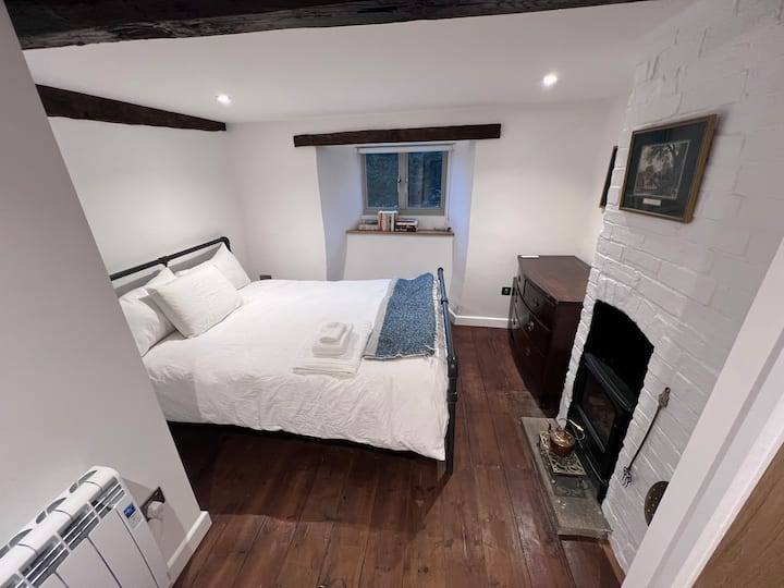 El dormitorio 1 ofrece un acogedor refugio con una cama tamaño king, armario empotrado, cómoda y una encantadora chimenea eléctrica para mayor calidez y ambiente. Perfecto para relajarse después de un día explorando el pintoresco pueblo de Nunney.