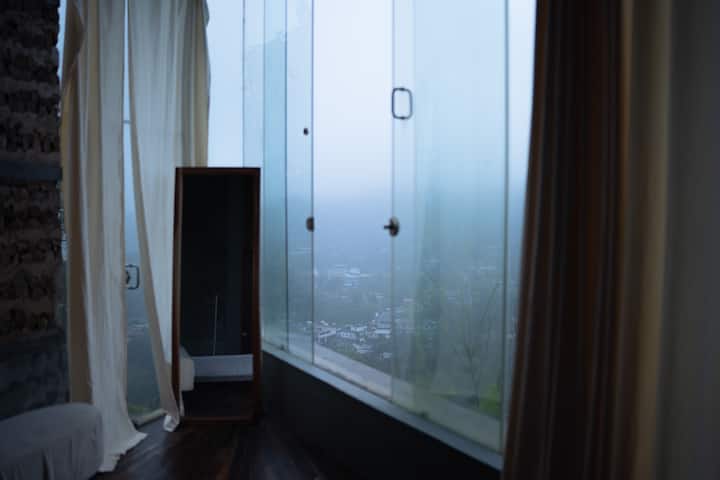 Leave your curtains open and let nature do the rest. Open your long glass windows to the hills. Let the mist drift in. In the morning, the soft, bright light wakes you up and at night, you can see the stars and the moon right from your bed.
