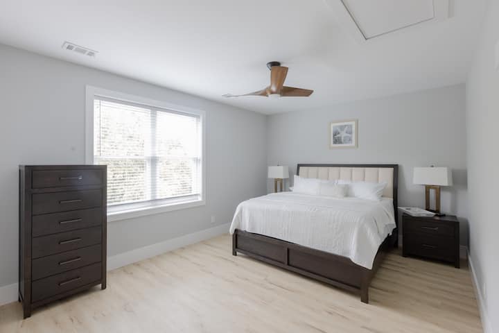 Habitación muy grande con cama tamaño king. TV inteligente de 55 pulgadas.  Baño privado con dos lavamanos y ducha con bañera. Vista parcial al pantano.
