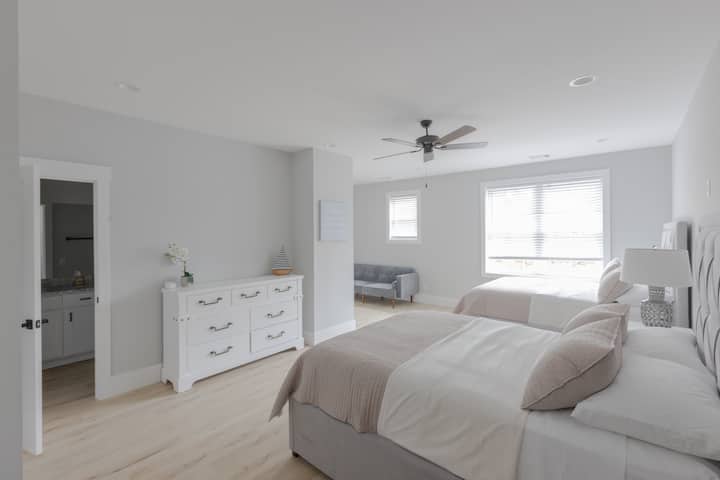 Habitación muy grande con dos camas tamaño queen.  Zona de estar con sofá cama y TV de 55 pulgadas.  Baño en la suite con dos lavabos, ducha, bañera y armario.