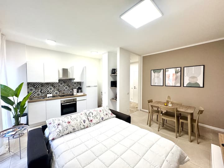 Otvorená obývacia izba s rozkladacou pohovkou, vybavenou kuchyňou a jedálenským kútom 