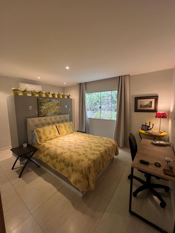 Соба со стандарден куќен кревет со поглед кон градината, плакар зад креветот