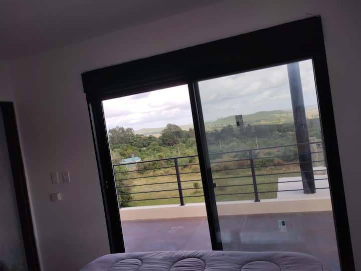 Izba na poschodí s manželskou posteľou veľkosti Queen. S východom z terasy a elektrickými závesmi.