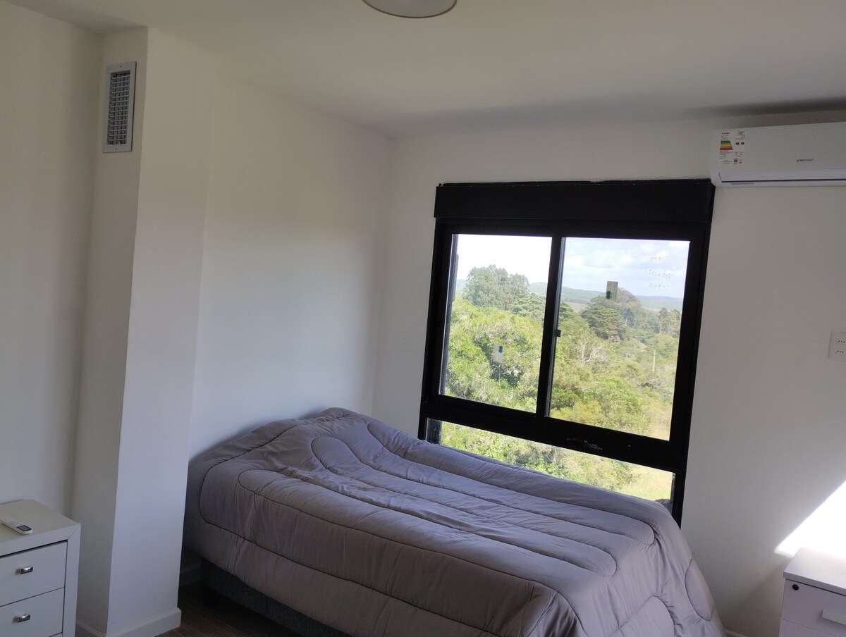 ห้องชั้นบนมีเตียงครึ่งหนึ่งและเตียงของคนทะเลอีกเตียงหนึ่ง พร้อมทางออกระเบียงและม่านไฟฟ้า