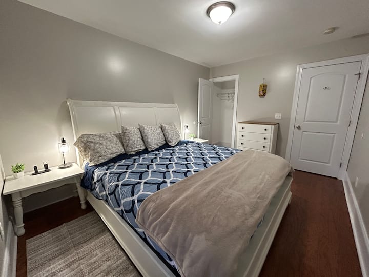 クローゼットとドレッサー付きのキングゲストベッドルーム。 