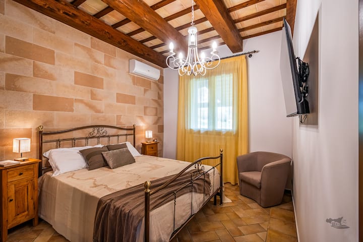 Isang komportableng rustic - style na silid - tulugan na may wrought iron bed, mainit - init na earth - tone accent, at nakalantad na mga kahoy na sinag. Maginhawang matatagpuan sa tabi ng banyo na kumpleto ang kagamitan, perpekto ito para sa nakakarelaks at komportableng pamamalagi.