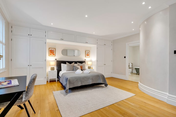 Dormitorio moderno con una cama acogedora, armarios empotrados y un espacio de trabajo.
