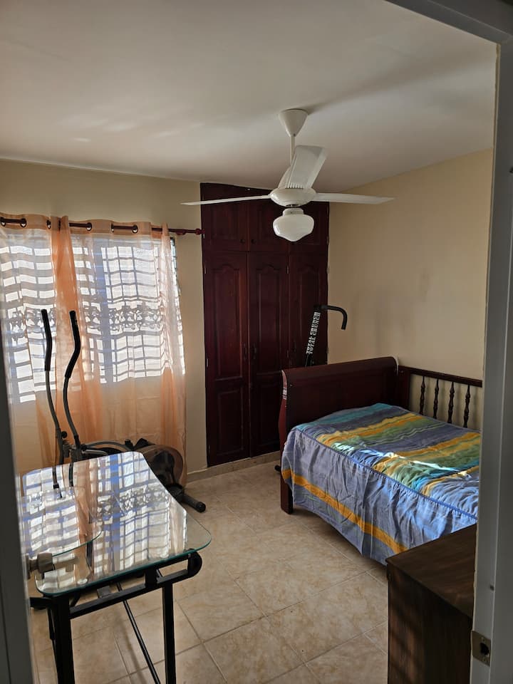 Habitacion con mesa de trabajo y maquina de ejercicios
