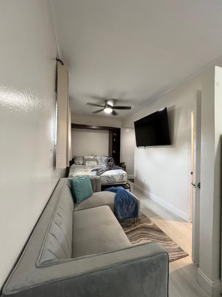 Sofá seccional que se puede utilizar para dormir, ubicado en el “espacio habitable” al pie de la cama tamaño queen.