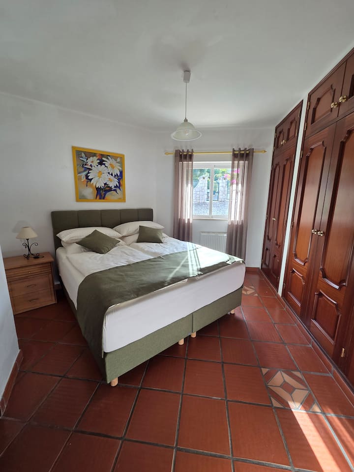 Habitación doble con cama tamaño queen y baño privado (nuevo en 2025) con ducha. La habitación está orientada al este, hacia el camino de entrada/entrada principal
