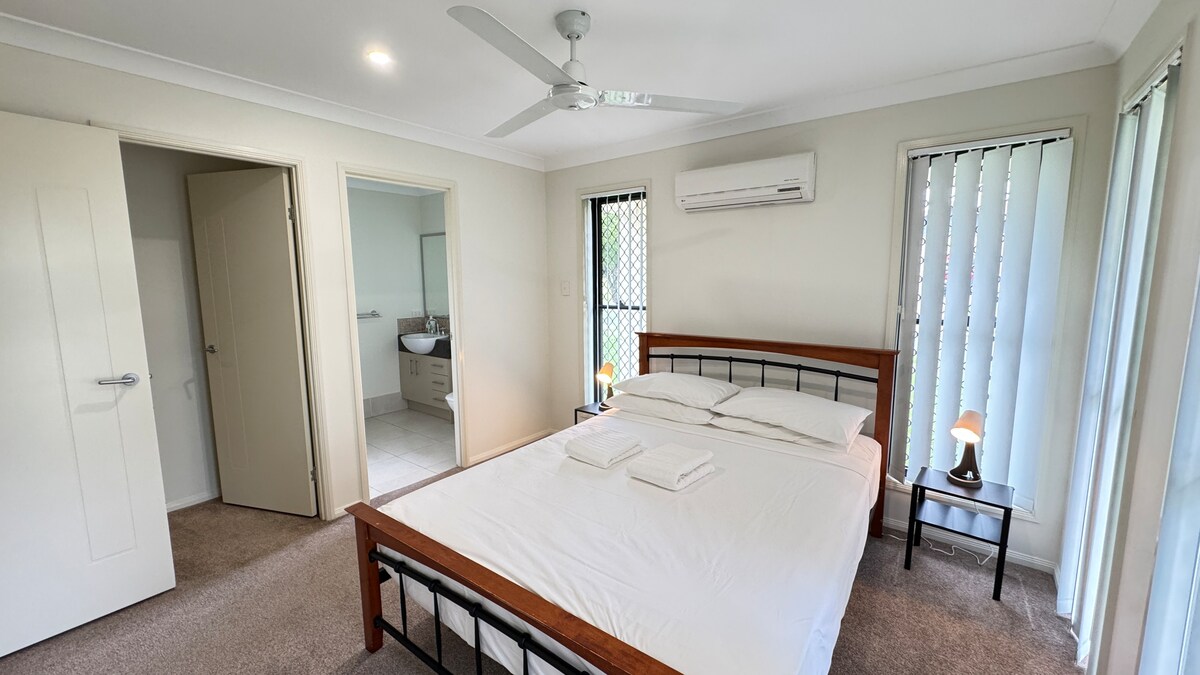 غرفة نوم رئيسية مع حمام داخلي ومكيف هواء