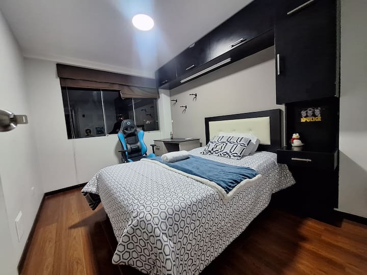 Chambre secondaire avec lit double, bureau avec chaise, placard