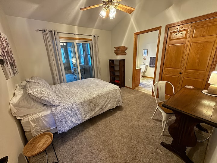 غرفة نوم في الطابق الرئيسي مع حمام متصل ومساحة عمل مخصصة. السرير بالحجم الكامل (أو مزدوج).