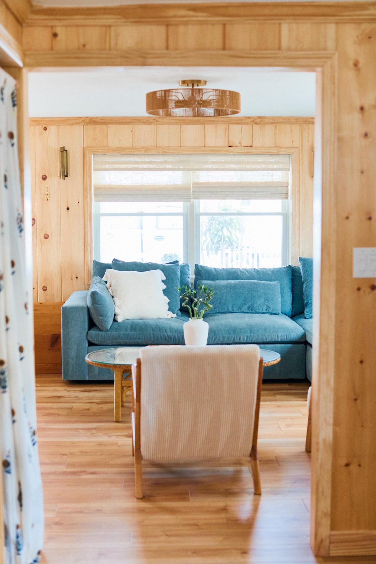 Cozy living room with natural light and knotty pine walls, LVP flooring