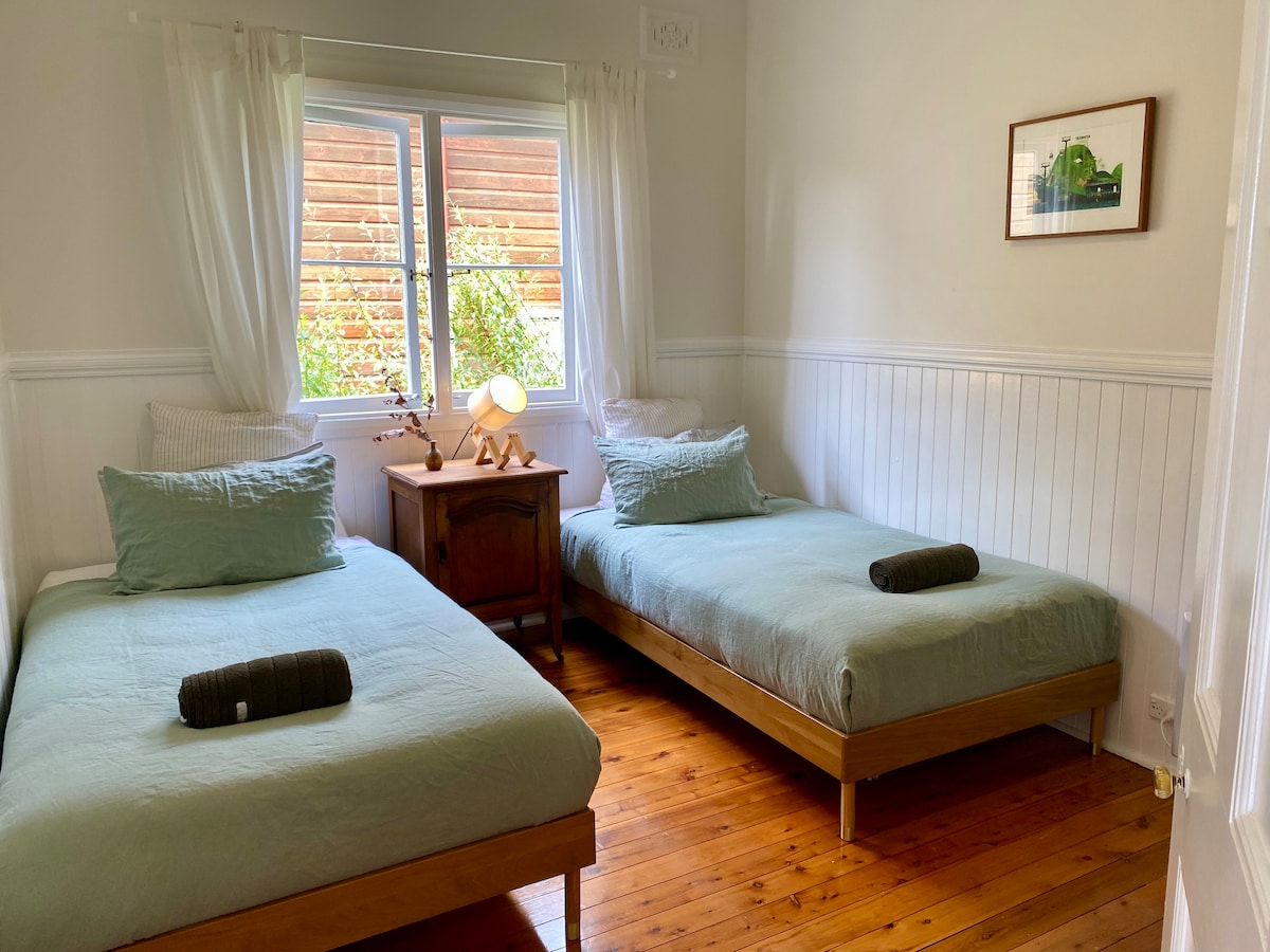 Rest easy in this inviting bedroom, featuring two king single beds perfectly suited for adults or children. A ceiling fan and wall-mounted electric heater ensure comfort year-round, while quality French flax linen bedding elevate your stay.