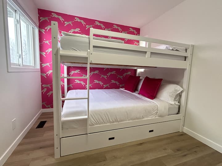 Chambre familiale avec deux matelas queen de luxe dans une configuration de lits superposés personnalisée. Les deux lits comprennent des matelas de haute qualité et de la literie haut de gamme, créant un espace confortable et élégant parfait pour les couples, les amis ou les familles.