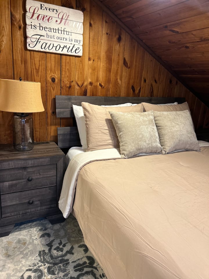 מיטת קווין סייז אידיאלית המצוידת בכל התקני החשמל הדרושים לטלפונים ולמכשירים אחרים.