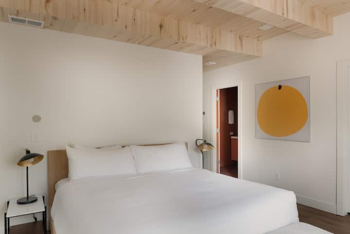 Primary bedroom features a king bed, desk, and ensuite bathroom.