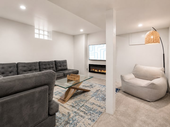 La sala de estar 2 está en el sótano. Tiene un gran sofá seccional, silla de pufs, TV de 55"y chimenea. ¡Está conectado a la sala de juegos con un tablero de dardos, un jukebox y un juego de arcade!